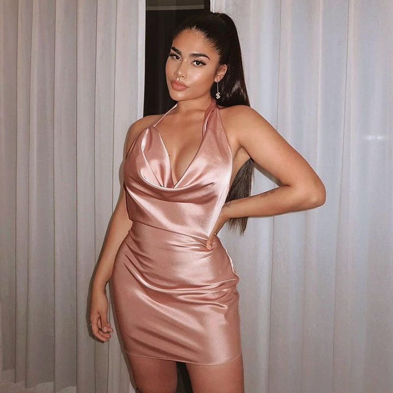 Woman wearing a pink satin dress standing against a neutral background